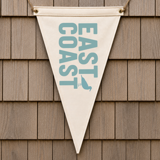 Triangle-shaped pennant banner with 'East Coast' text hanging on a wooden wall